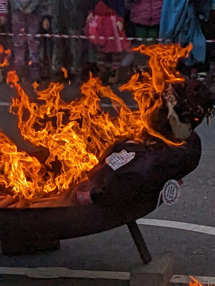 A burning strawman is lying in a big metal tray