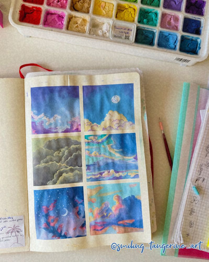 A photo of my sketchbook, opened on the page with my gouache cloud studies. Above the sketchbook is my Himi gouache paint box, which I used for these paintings