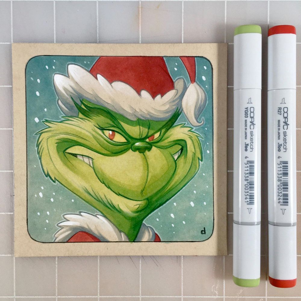 A marker drawing of The Grinch in his Santa outfit on a 5" square of toned tan paper.  To the right are two Copic markers.