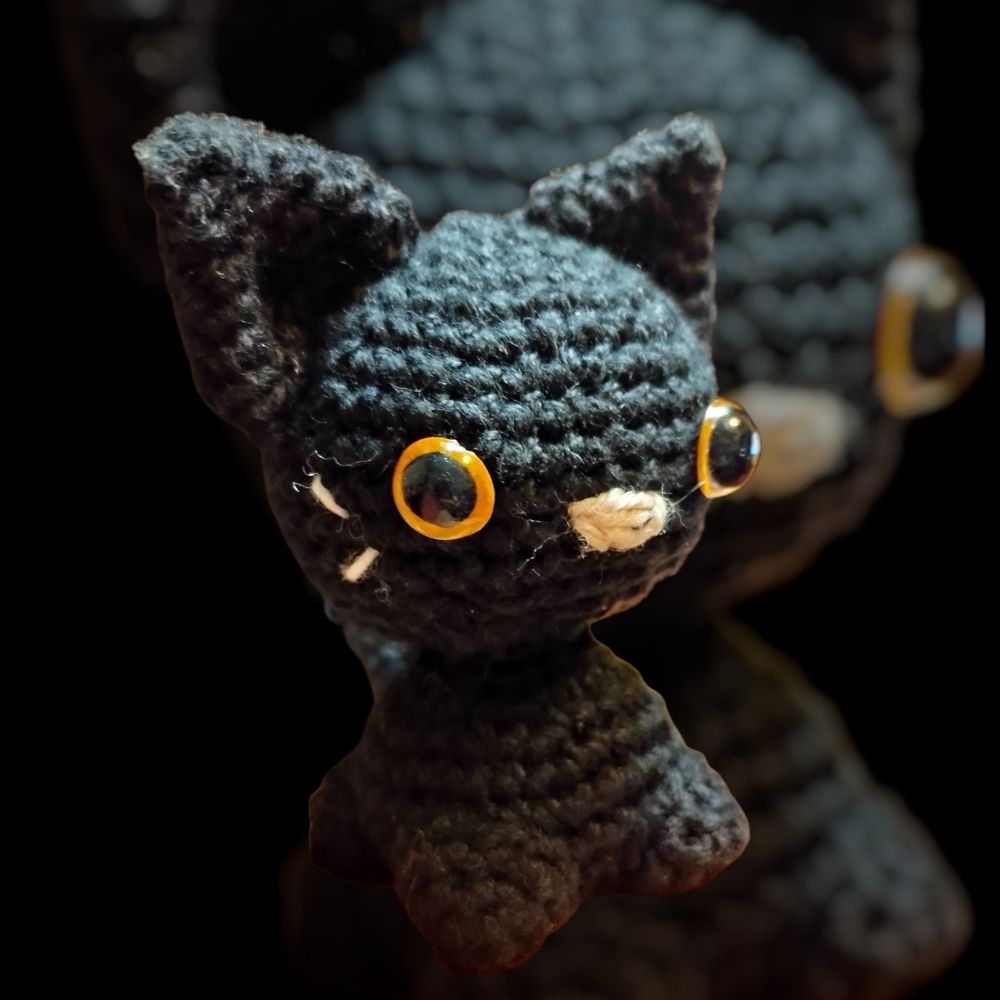 Gato tejido a crochet con el mismo gato tejido a crochet como fondo borroso