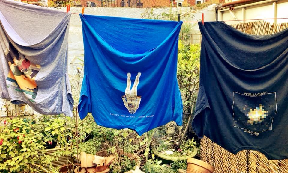 Three T-shirts hanging upside down on a washing line. L - R, Another Green World, I Sing The Body Electric, and Spectrum