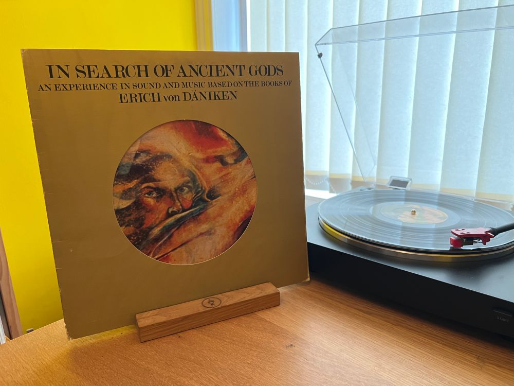 The cover of In Search Of Ancient Gods by Absolute Elsewhere stands next to the turntable playing the LP