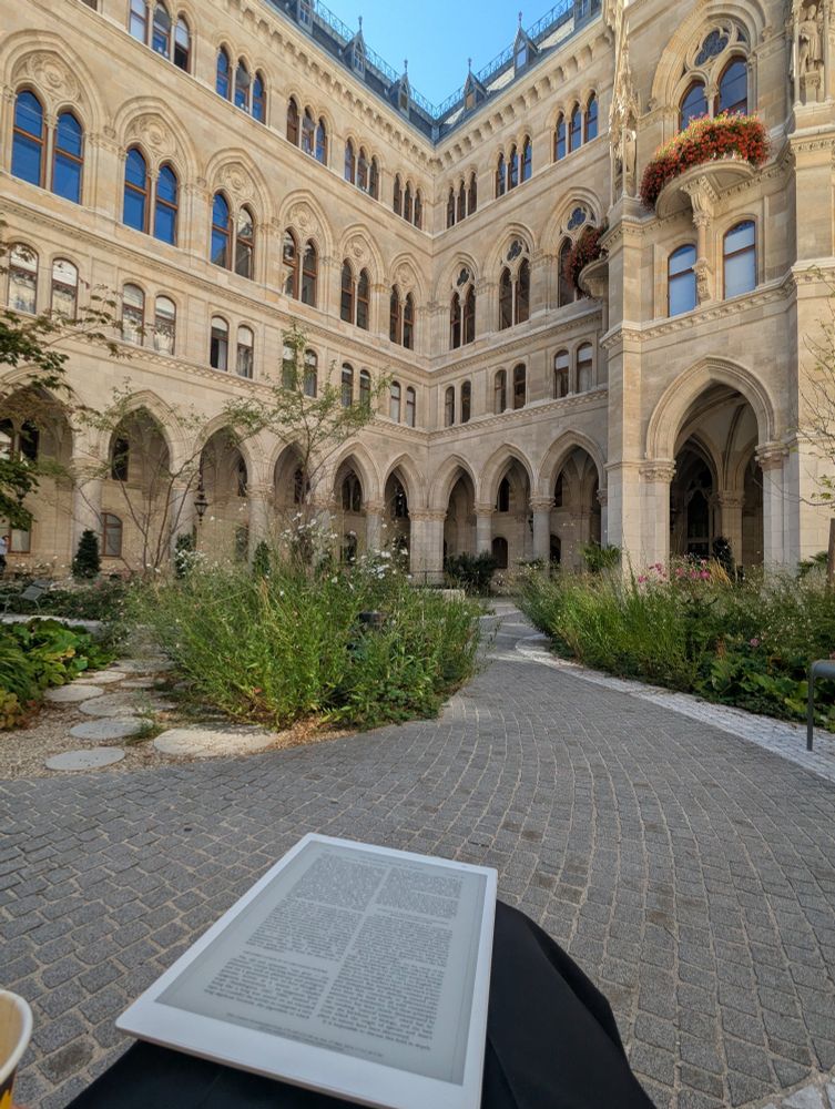 Courtyard perspective of the Rathaus building, with an ebook in the lap