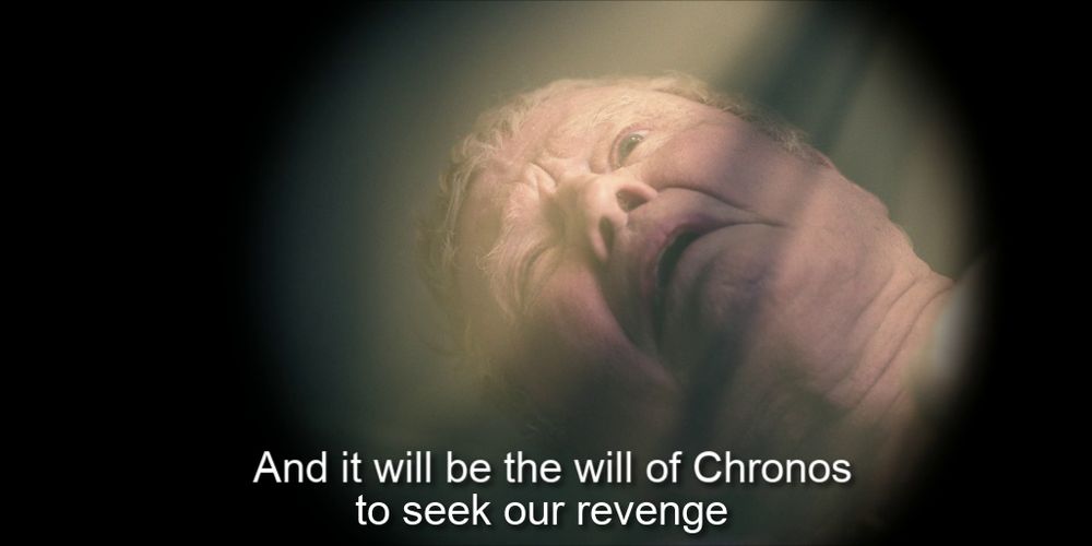 An irised-in shot of Jon Voight looking up as a radiant light comes down with the caption "And it will be the will of Chronos to seek our revenge"