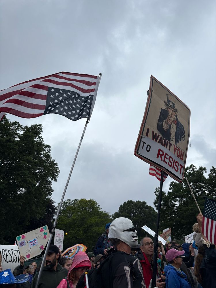 Upside-down American flag flown next to sign of Uncle Sam saying, “I want you to resist.”