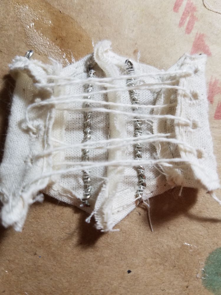 A detail of the corset interior showing the spiral metal boning and hand-sewn eyelets. 