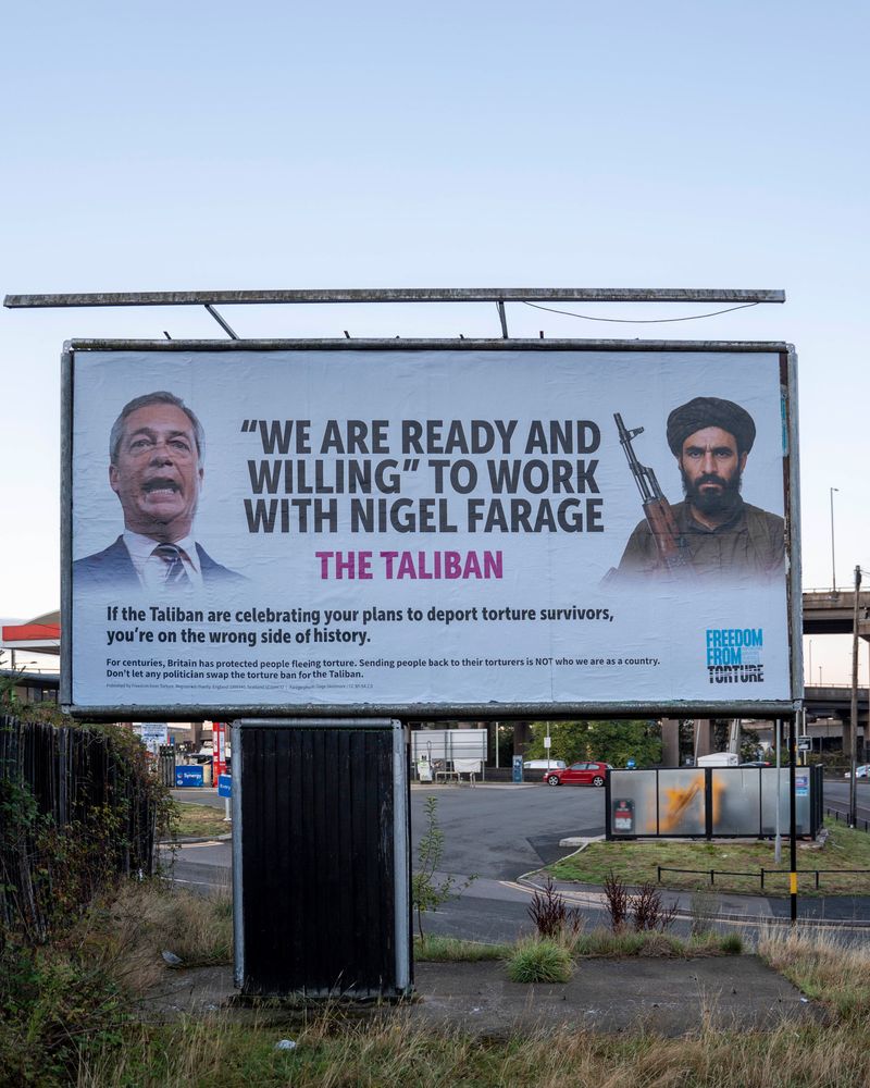 Billboard with photo of Nigel Farage. The Taliban is quoted saying they're ready and willing to work with Farage