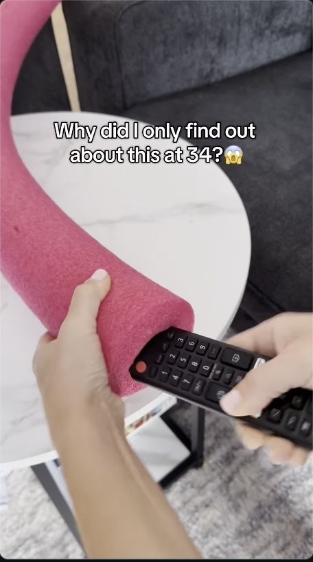 Somebody awkwardly shoving a TV remote control into the orifice of a foam pool noodle with the caption "why did I only find out about this at 34?"
