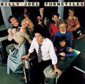 album cover for Billy Joel Turnstiles where he's in the subway with a crowd of eclectic 70s New Yorkers behind him. Billy wears a tie and white button down, raising his eyebrows knowingly to the camera.
