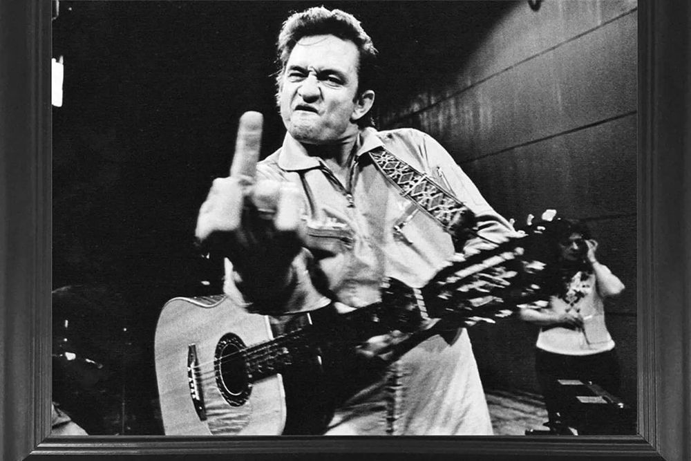 Johnny Cash throwing up an emphatic middle finger during a performance at San Quentin prison.