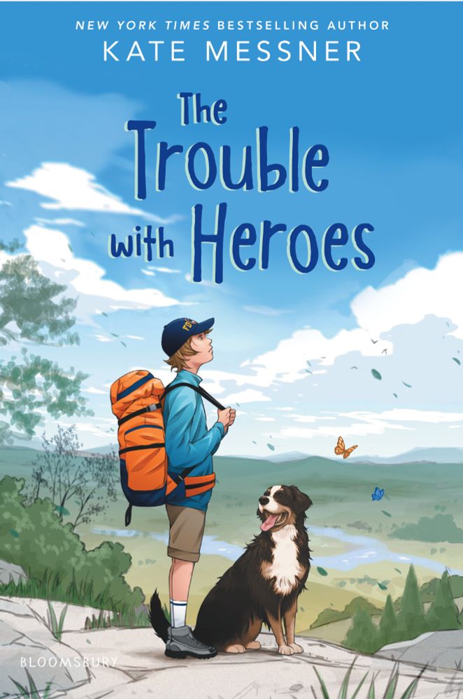 The book jacket for THE TROUBLE WITH HEROES by Kate Messner features a kid wearing an FDNY baseball cap, shorts, windbreaker and large orange backpack, pausing mid-hike to look at the sky with a valley in the Adirondacks behind him. He's accompanied by a St Bernard dog who is looking at him with his tongue out in doggish fashion.