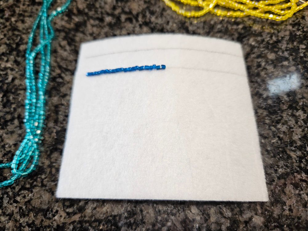 A simple row of blue beads on white fabric.