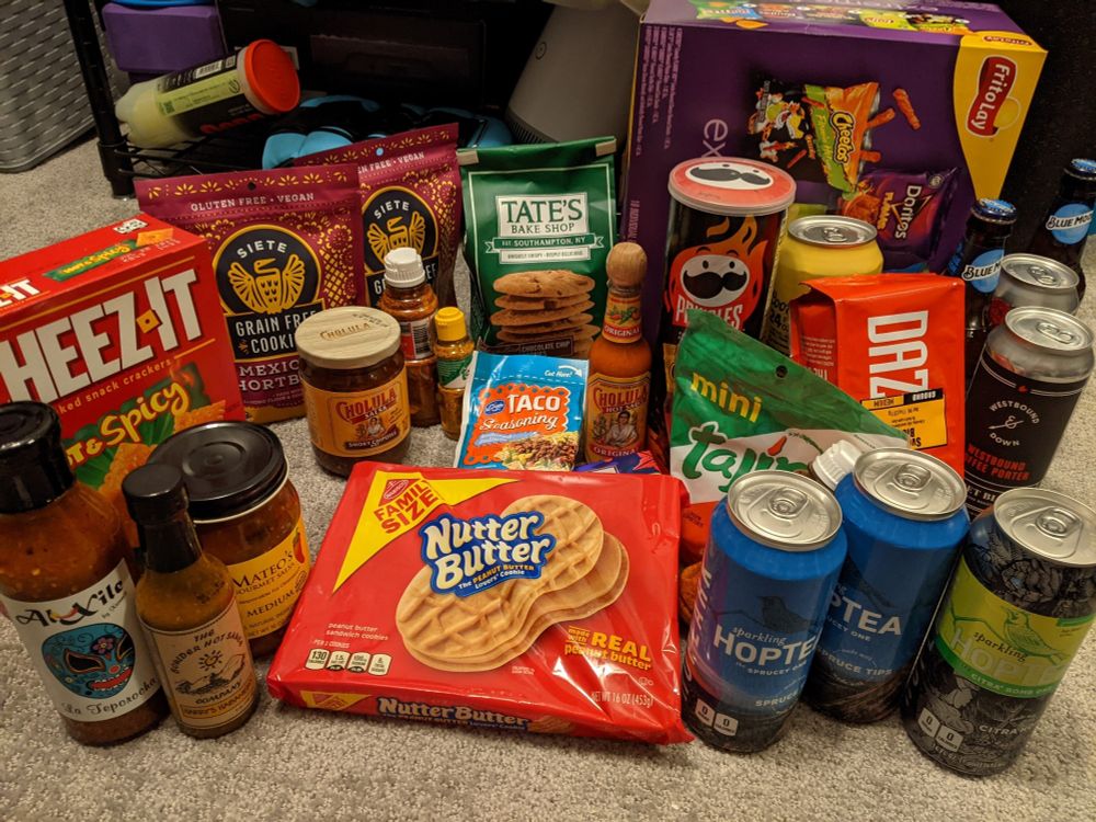 A photo with many snacks and beverages such as nutter butters, salsa, hop water, coffee, cookies, and Tajín all crammed together.