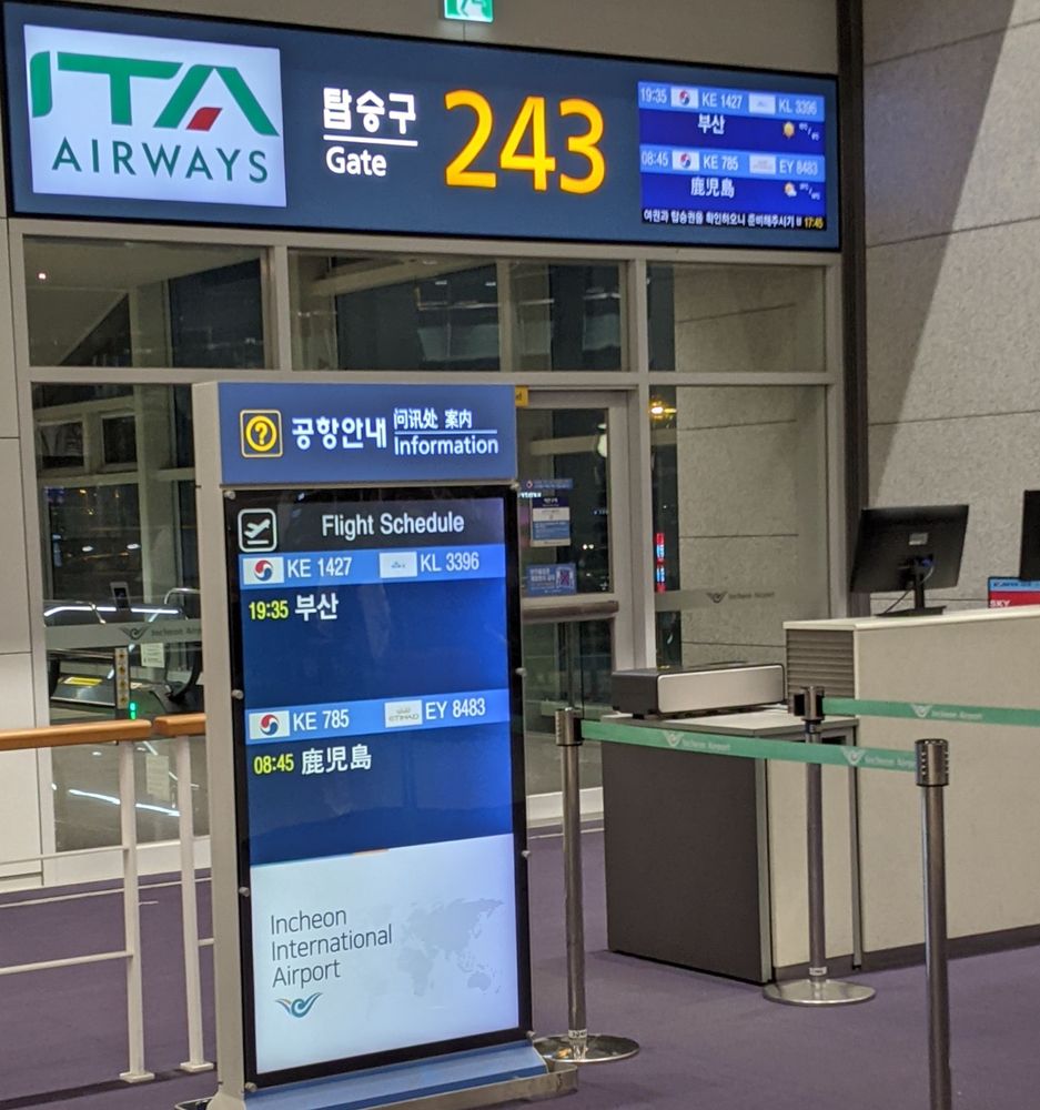 A photo of an airport gate with a flight leaving for Busan, South Korea