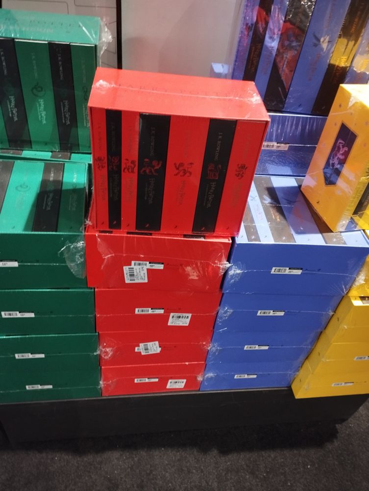 Caja de los 7 libros de Harry Potter alternando los colores rojos y negros.