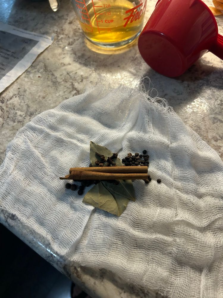 Spices on a piece of cheesecloth. Bay leaves, cinnamon slick, peppercorns, allspice 