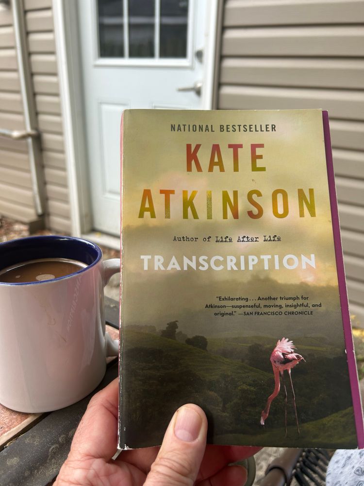Coffee on a patio table with the novel Transcription by Kate Atkinson