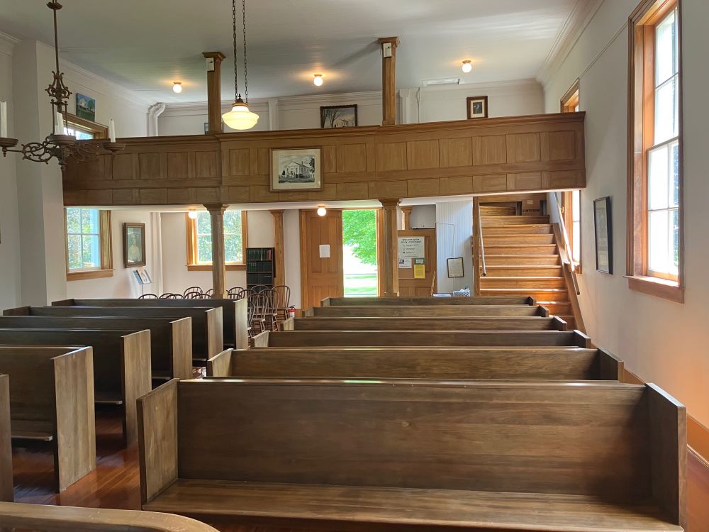 A view looking from the altar to the back of the chapel, showing the choir loft and the front door. 
