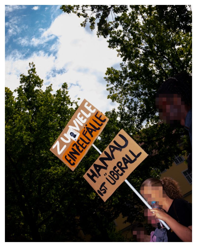 Neben Transparenten gibt es auch viele selbstgemalte Schilder, auf denen Demonstrant*innen ihre Kritik äußern.
Auf dem Foto trägt eine Frau zwei Schilder, auf denen "Zu viele Einzelfälle" und "Hanau ist überall" steht.