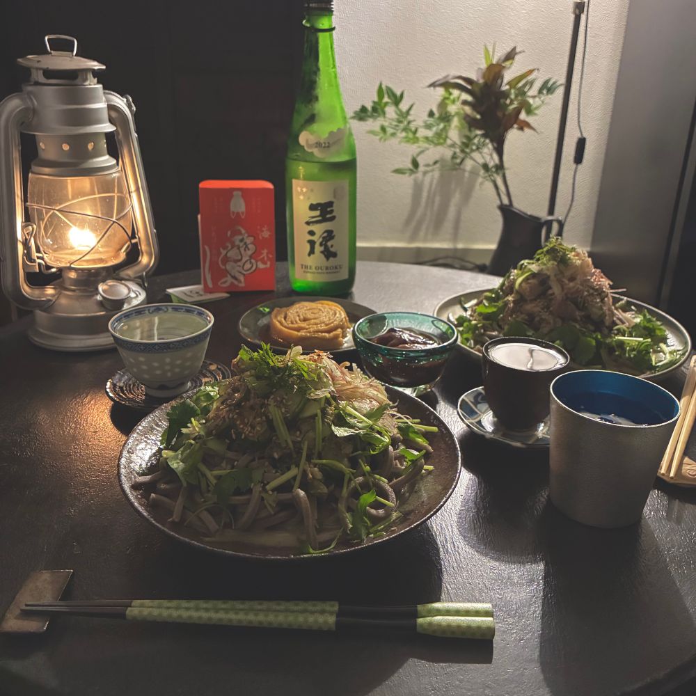 薬味の沢山載った　胡麻仕立ての蕎麦、海木ほのじの　おあげの缶詰め、ホタルイカの沖漬けを　肴に　日本酒を飲むところの写真。