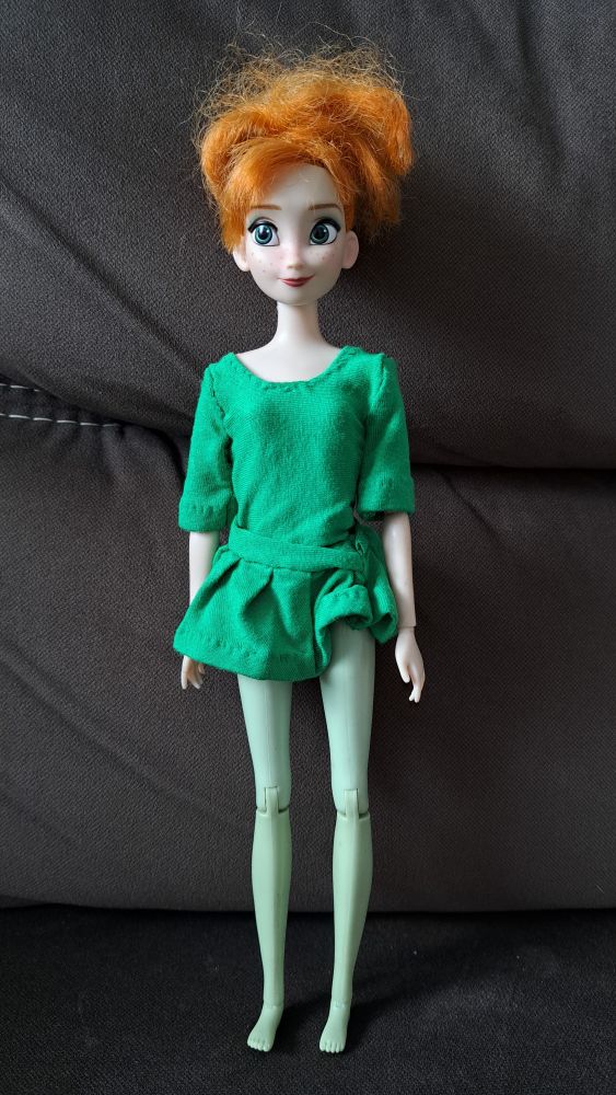 Photo of Frozen's Anna doll with short hair tied up in a ponytail dressed only in handmade green blouse. Her legs are painted light green.