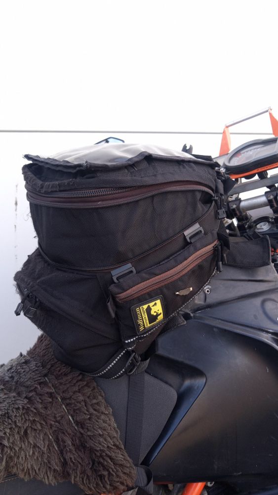 7-year-old Wolfman motorcycle tank bag, used daily as main transport. Remarkably durable—still going strong after over 70,000 miles across Europe, including trips to Spain, the NC500 in Scotland, Orkney, Wales, and all over the UK. Only needed to replace the clips. 20L capacity still handles shopping and travel gear with ease. Discontinued now, but no replacement has matched it.
