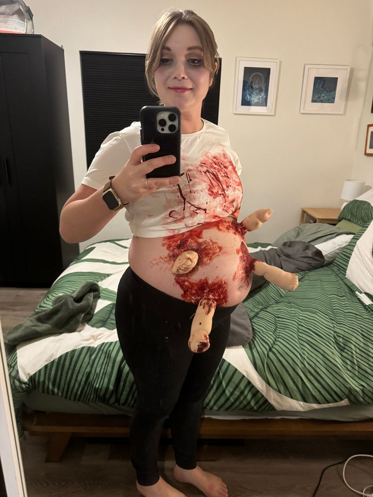 A photo of pregnant me with baby doll arms erupting from my belly, covered in blood (from the opposite angle)