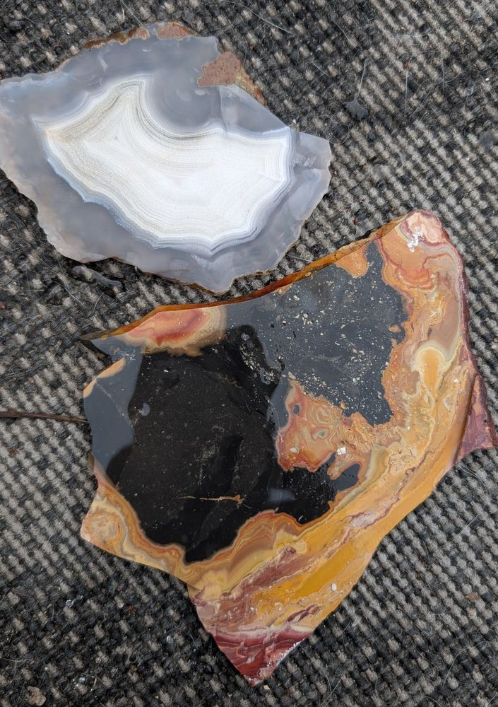 Two more slabs, one is gray and white, the other is black, orange and red