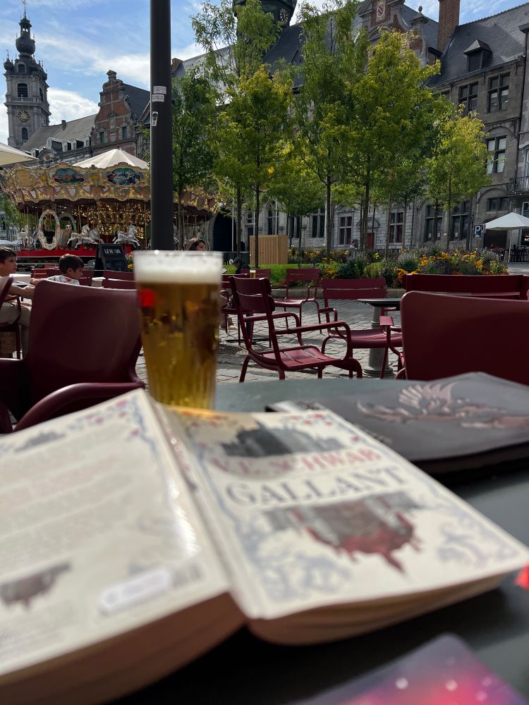 Øl og boka Gallant - med utsikt mot karusellen på Grand Place