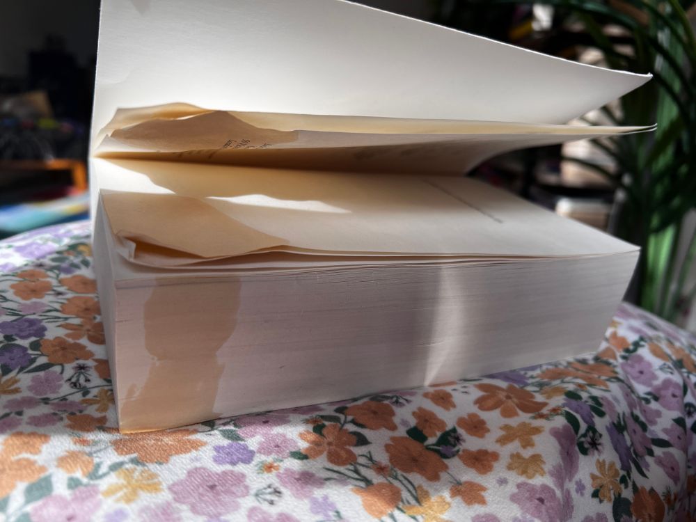 En bok med kaffeflekker ligger med sidene vendt mot kamera.