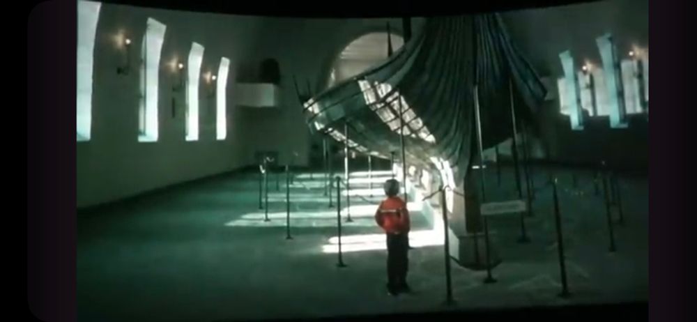 Screenshot from "The Spirit of Norway" film from the post-show of the Maelstrom ride at WDW EPCOT Norway pavilion. You boy standing beside Viking ship.