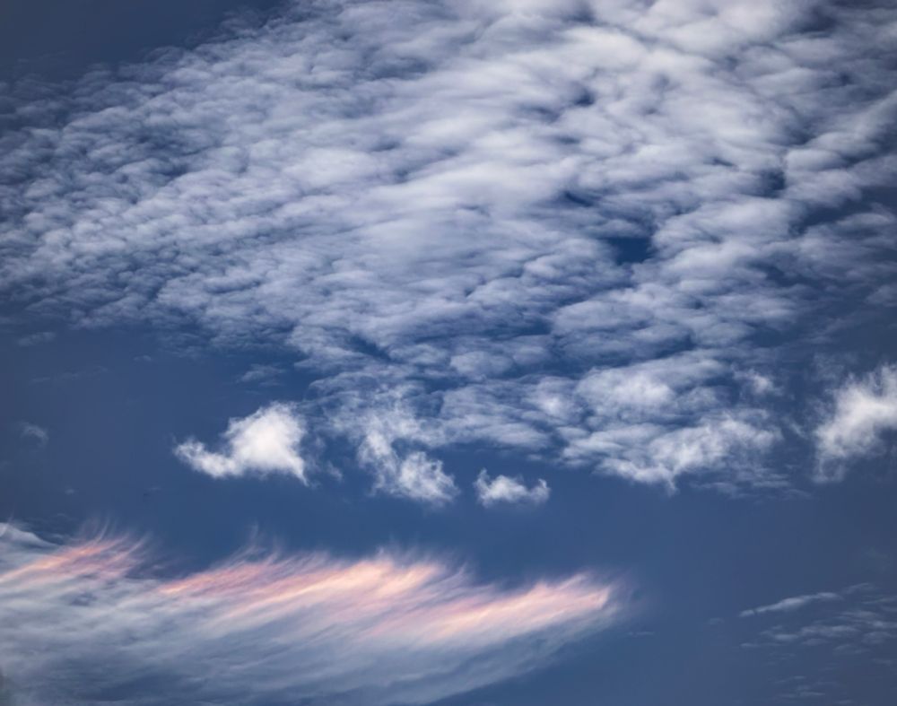 Taken at the stop light just now. A simple sky picture. Bottom frame the clouds appear pink and streaky...almost like fingers on a hand. Above, a mass of little tiny clouds, like little dots on a deep blue sky...hey BSKY🎉