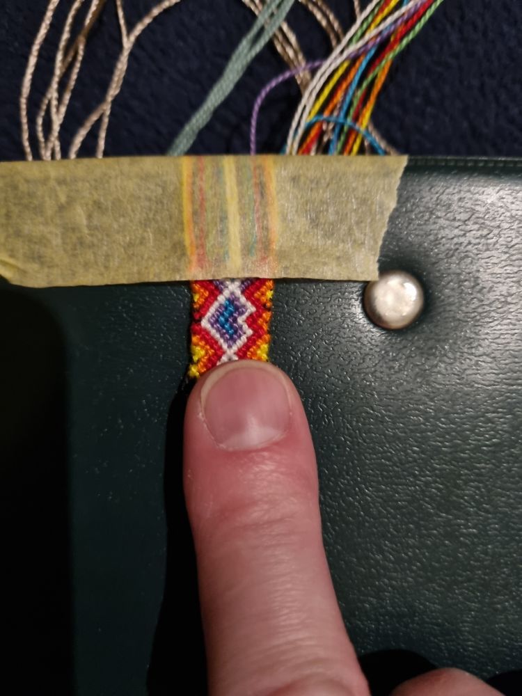 A photo of a friendship bracelets starting 20 rows and a human finger for comparion.

It's ca. 1.5 cm (0.6 in)

