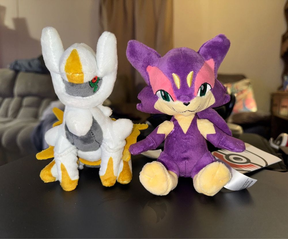 Two Pokemon Sitting Cuties plushies. On the left is Arceus and the right is Purrloin. 