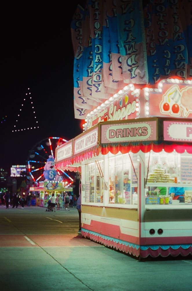 Photo of a fair stall with drone show in the background