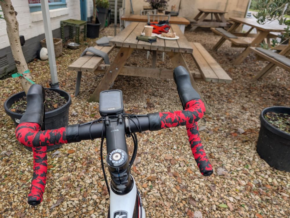 Jazzy red and black drop handlebars outside of coffee shop.
