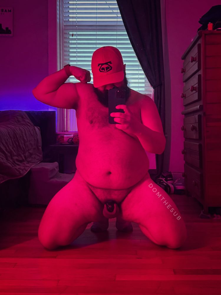 Photo of me kneeling naked taken in the mirror. I’m wearing a nasty pig hat that obscures most of my face. My locked nub is exposed 
