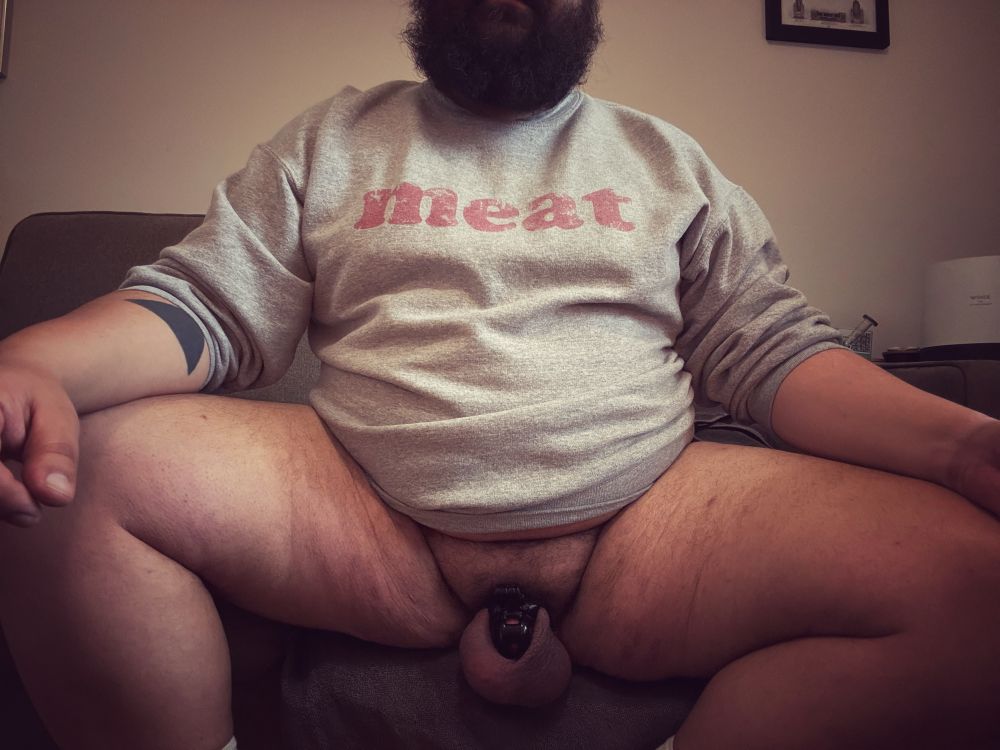 Selfie of me wearing only a meat zine sweatshirt and a cock cage 