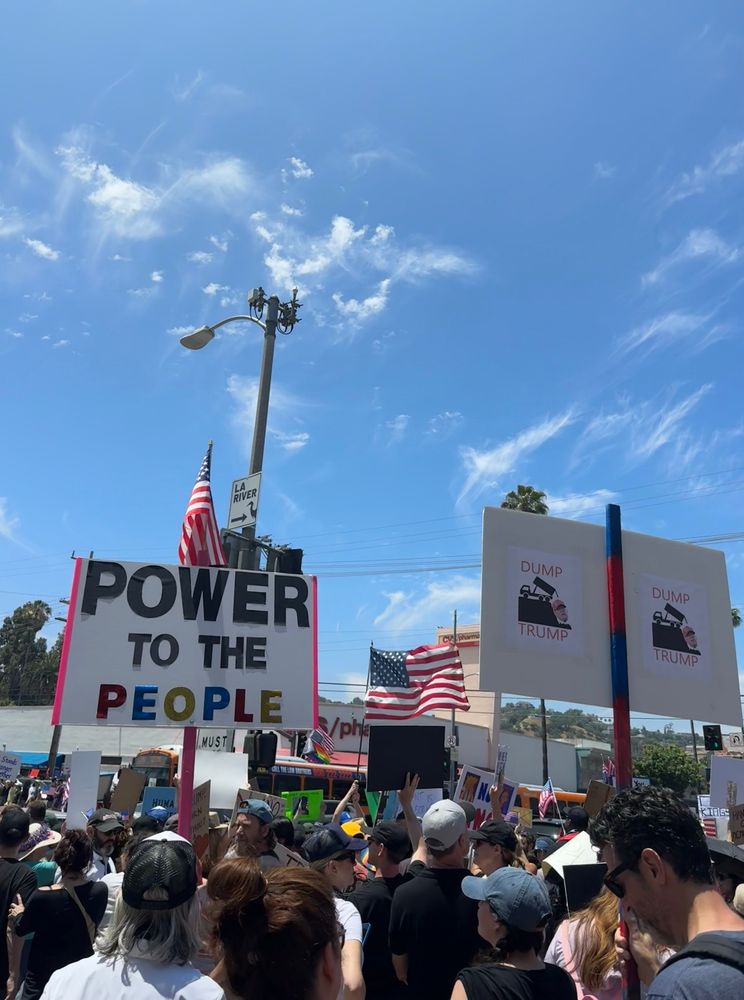 A protester on #NoKings day holds a sign that reads “Power to the People”