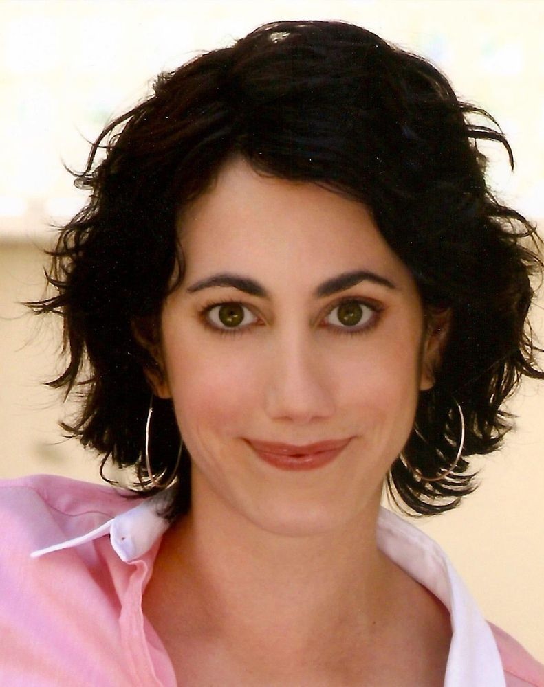 Picture of first nations woman, smiling mouth closed at the camera. She’s in a pink shirt, with a white collar. She’s wearing large silver hoop earrings. She has short wavy dark brown hair, dark brown eyebrows, and dark brown eyes. She was my cherished friend. She died in 2020 of myeloid leukemia.