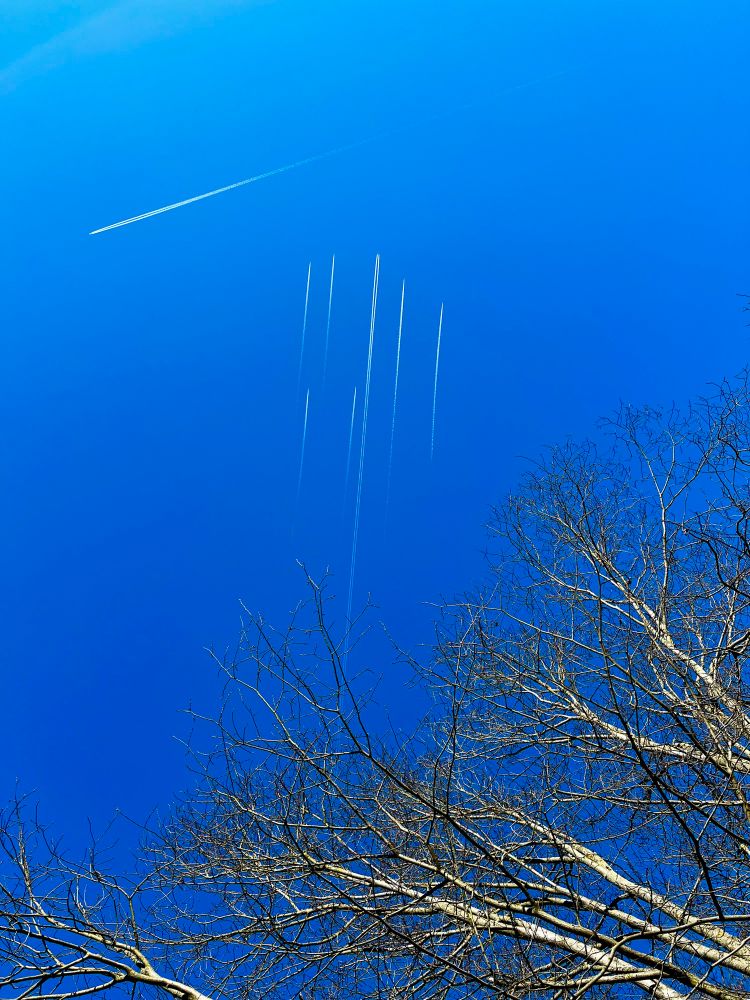 Am Himmel über Berlin ist eine Formation aus einem großen Flugzeug und sechs kleineren Begleitmaschinen zu sehen. 