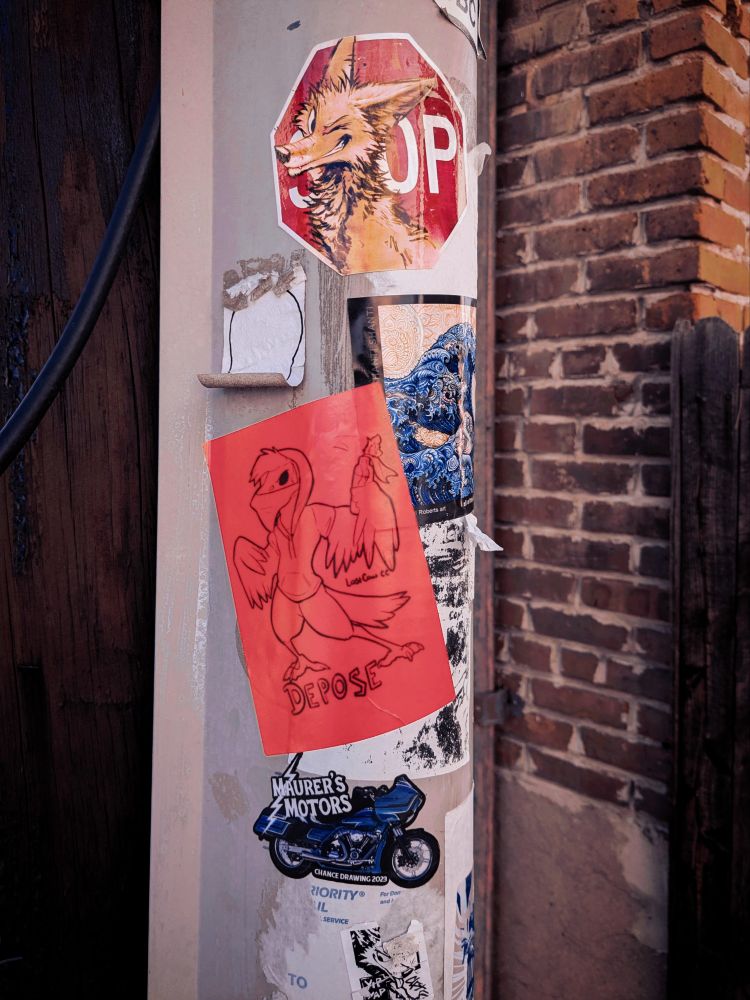 A power pole covered in stickers made by local artists.