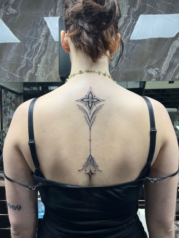 Une photo d'un tatouage dans le tiers supérieur du dos.