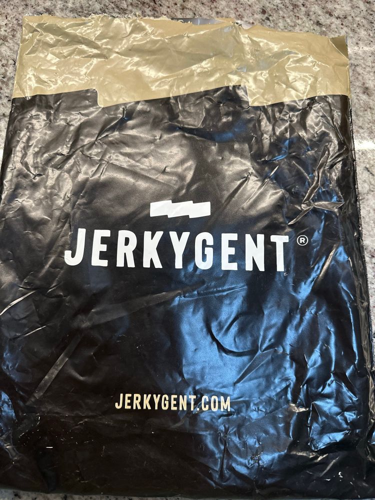 A discrete black wrapped package with the words “jerkygent” written on it from a mail order beef jerky website 
