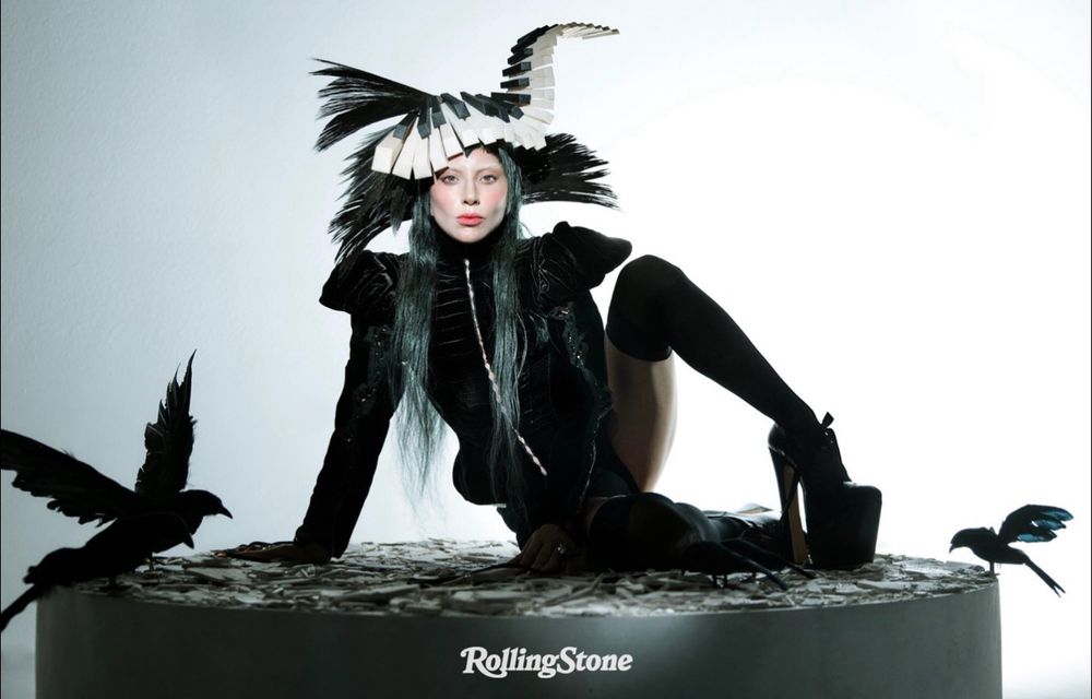 Lady Gaga in all black with a piano hairpiece surrounded by black birds 