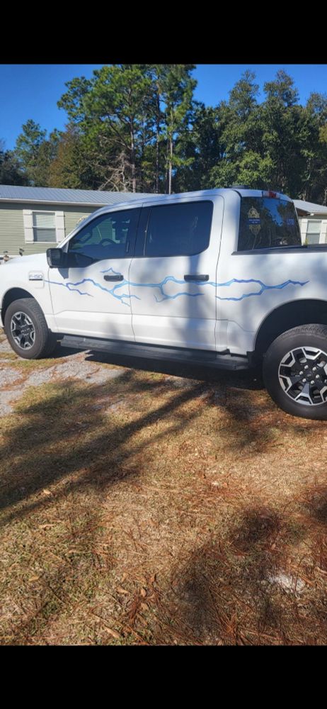 A white Ford F-150 lightning with a lightning bolt down the side