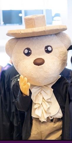 Someone dressed in the same clothes as Jeremy Bentham's auto-icon, namely a dark jacket, cream shirt with a ruffle, and a wide-brimmed hat - but it's a large teddy bear