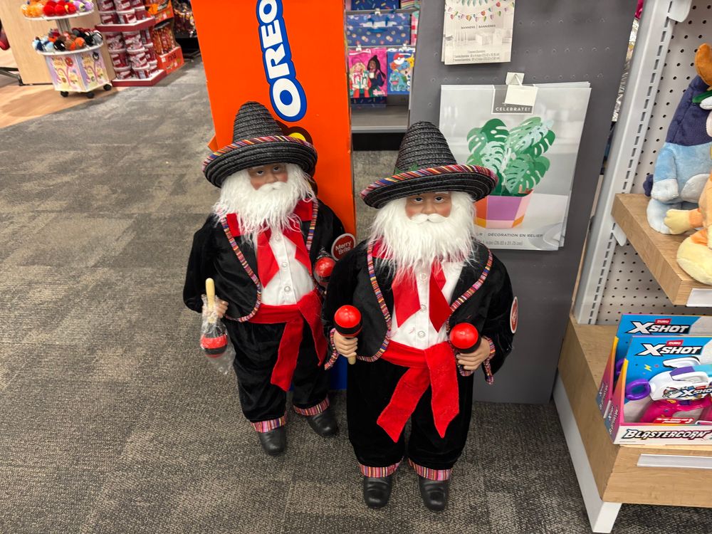 Two Santas maybe three feet tall with a generally pink skin tone, black sombreros, maracas, red sashes, black jackets and pants with colorful trim… man I dunno