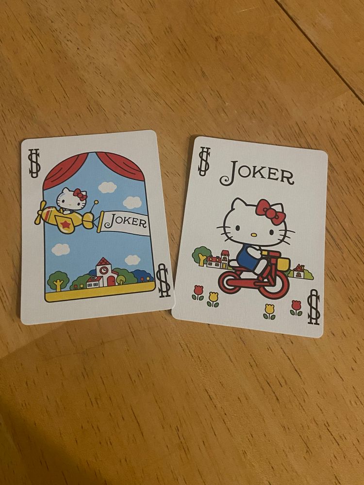 Joker cards showing hello kitty flying a plane and riding a bike. They’re very cute 