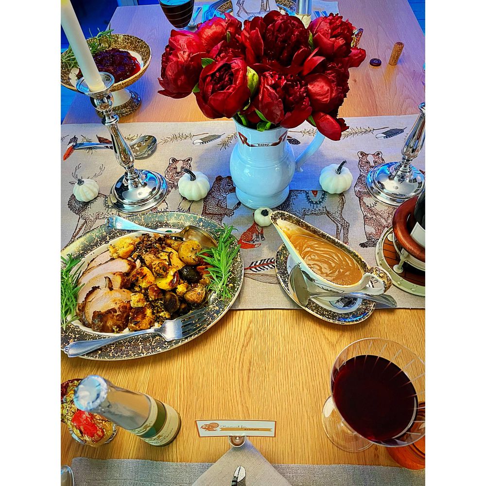 Dining room table withe platter of turkey and dressing and a goblet of wine 